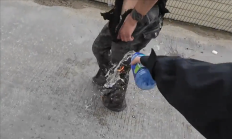 女子骑摩托车不慎摔倒引火烧身：一男子用饮料紧急扑救